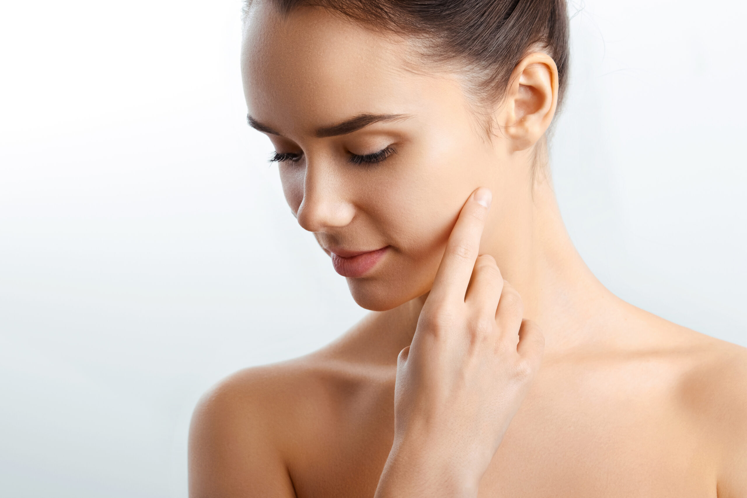 A woman gently touches her cheek